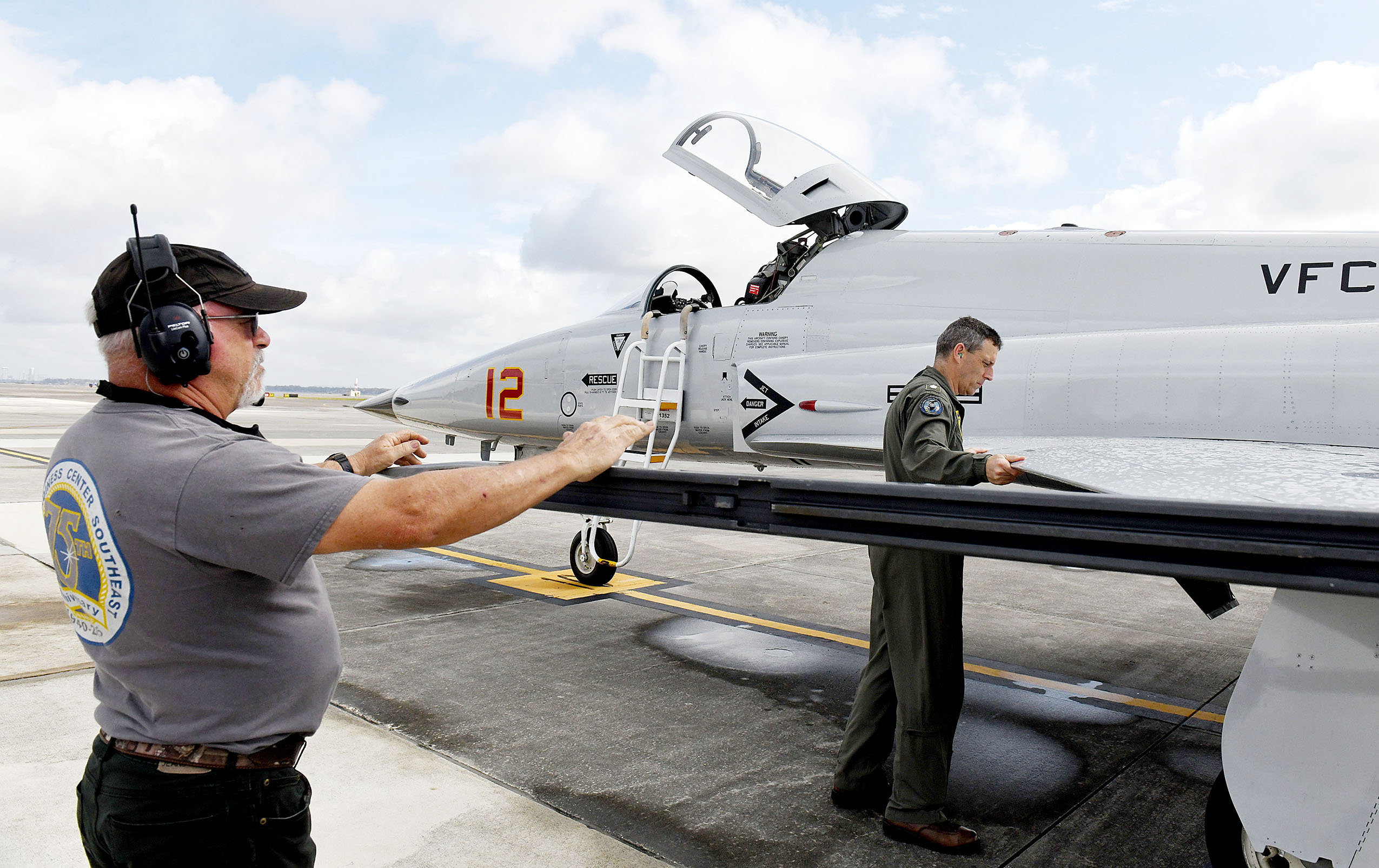 210301-N-DG679-017 JACKSONVILLE, Fla. (March 1, 2021) Fleet Readiness Center Southeast's (FRCSE) Adversary Production Office Commander, Mitchell Conover (right), pre-flights an F-5N Tiger II as Plane Captain, Joe Hawley (left), stands by to answer questions prior to take off. (U.S. Navy Photo by Toiete Jackson/Released)