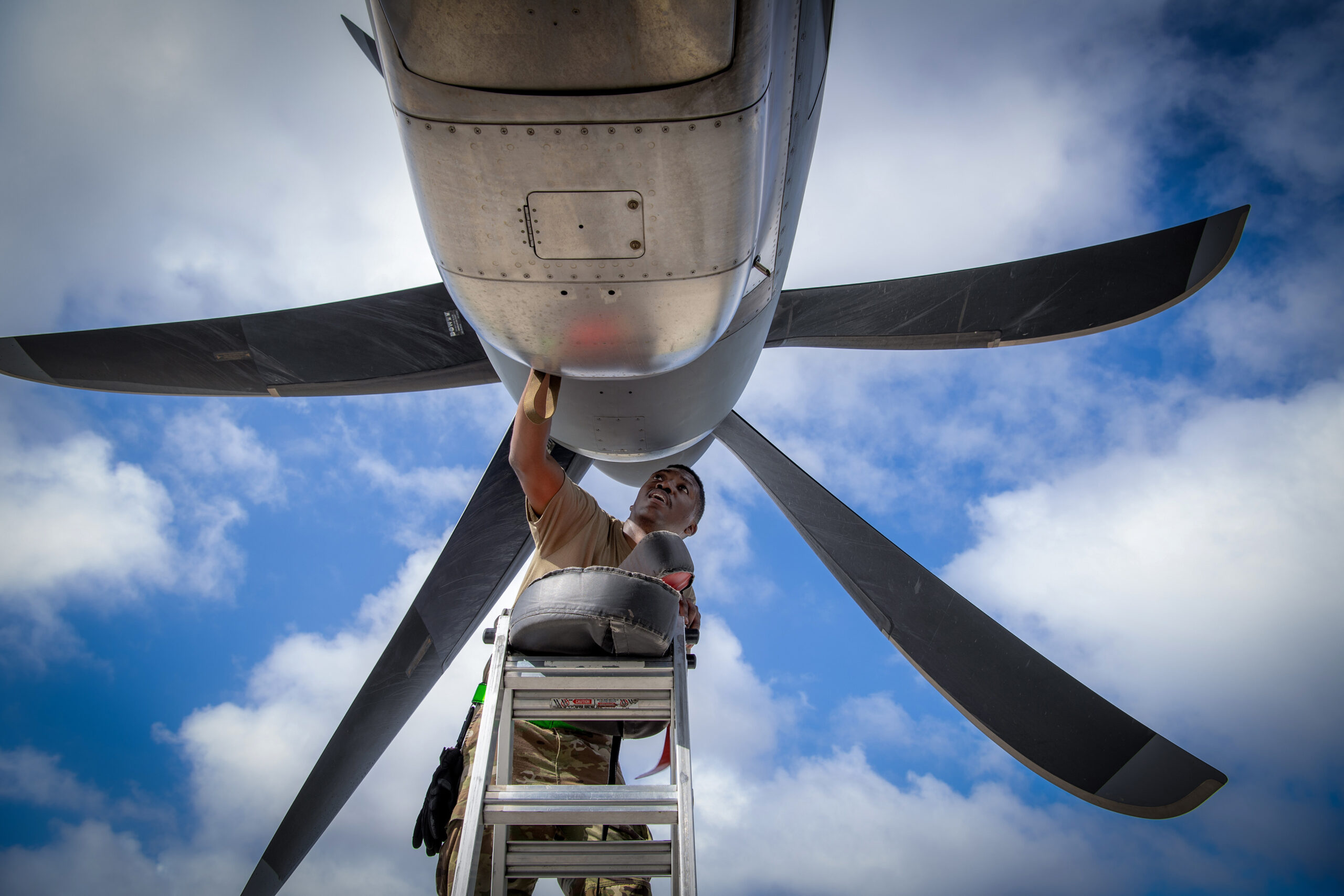 U.S. Air Force Staff Sgt. Arthur Smith, 374th Aircraft Maintenance Squadron crew chief, conducts a thru-flight inspection (TFI) at Andersen Air Force Base, Guam, Nov. 30, 2023, in support of Operation Christmas Drop 2023 (OCD 23). A TFI is a thorough inspection of an aircraft that is conducted before, during, and after flight to ensure safety and efficiency. This process includes a visual inspection for any signs of defects, functional checks to the engine and landing gear, and recording the results to ensure required maintenance has been performed. (U.S. Air Force photo by Yasuo Osakabe)